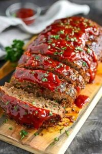 Moist homemade meatloaf topped with caramelized ketchup glaze and sliced for serving.